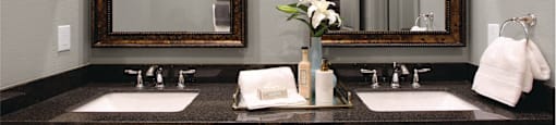 Double vanity bathroom with two mirrors and a black granite vanity top