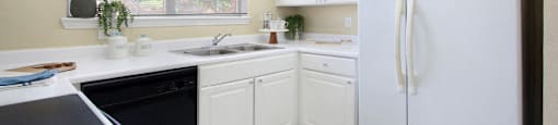 Luxury apartments with bright white kitchen, u-shaped kitchen, white cabinets, and side-by-side refrigerator at TurtleCreek apartments in West Des Moines, Iowa