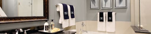 A double vanity bathroom with granite vanity top, a glass stand-in shower and a separate bathtub