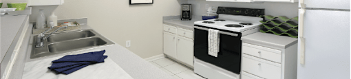 Bright white kitchen with porcelain tile floors at Breckenridge Apartments in Omaha, Nebraska