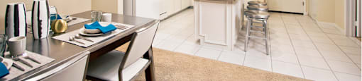 Spacious dining room and spacious kitchen with white cabinets, lots of cabinet space, lots of counter space, kitchen island, prep island at Embassy Park Apartments in Omaha, Nebraska