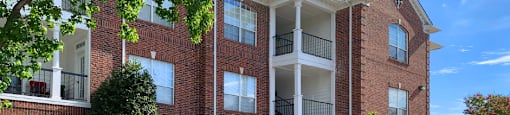 Gated community near the Galleria with brick exteriors, lush landscaping, covered parking, and detached garages.