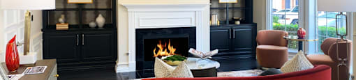 a living room with a red couch and a fireplace