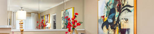Luxury apartments with spacious dining room, wood plank floors, breakfast bar, mirror accent wall, and 9-foot ceilings at Kensington Square Apartments.