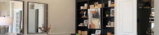 a dining room with a table and chairs and a bookshelf in the background