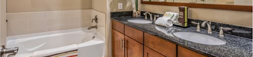 Luxury bathroom with granite countertops, glass shower and separate soaking tub at Villa Piana Apartments in Dallas