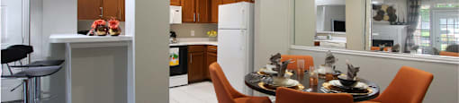 Luxury apartments with wood grain plank floors, dining room, u-shaped kitchen, mirror accent wall, and breakfast bar at Lenox Village Apartments in Lincoln, Nebraska