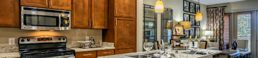 Luxury apartments next to the Galleria in Dallas with granite countertops, stainless steel appliances, built-in wine rack, kitchen island, and porcelain tile floor at Villa Piana Apartments in Dallas