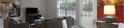 Apartments in southwest Omaha with spacious layout, open floor plan, oversized windows, and gray wall color at Breckenridge Apartments
