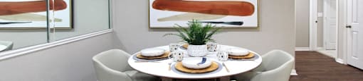 Spacious dining room with plank wood floors and mirror accent wall at Prestonbridge Apartments in North Dallas