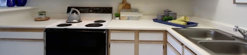 Spacious kitchen with extra cabinet space, extra counter space, tiled floors, bright white kitchen, at Tanglewood Apartments in Lincoln, Nebraska