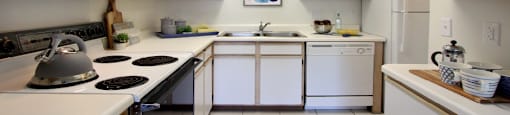 Spacious kitchen with extra cabinet space, extra counter space, tiled floors, bright white kitchen, at Tanglewood Apartments in Lincoln, Nebraska