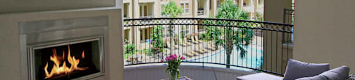 Large spacious balcony with patio fireplace and pool view at Tuscany Walk Apartments in Houston Texas.