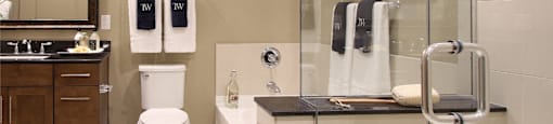 Luxury apartments with spacious bathrooms with oval soaking tub, separate shower with glass enclosure, and granite slab vanity top Tuscany Walk Apartments in Houston.
