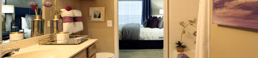 Luxury apartments with spacious bathrooms with tiled floors, extra storage and cabinet space, oval soaking tubs, granite countertops, and washed oak cabinets in north Dallas at Kensington Square Apartments.