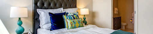 a bedroom with a large bed and a door to a bathroom