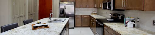 Luxury apartments with spacious open floor plan, granite countertops, stainless steel appliances, built-in wine rack, kitchen island, and porcelain tile floor at Bellemeade Apartments in west Des Moines