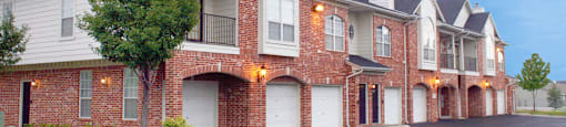 Luxury apartments in central Omaha with attached garages, red brick exterior, lush landscaping, and scenic views at The Biltmore Apartments