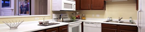 Spacious kitchen with lots of cabinet space, side-by-side refrigerator, porcelain tile floors, and lots of counter space at The Biltmore Apartments in Omaha, Nebraska