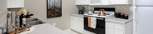 Bright white kitchen with porcelain tile floors at Breckenridge Apartments in Omaha, Nebraska