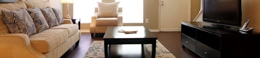 Spacious living room, spacious townhome with hardwood floors, and private entries at Briarwood Apartments in Houston.
