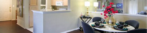 Luxury apartments with spacious kitchen, wood plank floors, breakfast bar, washed oak cabinets, mirror accent wall, spacious dining room, extra pantry storage, and 9-foot ceilings at Kensington Square Apartments.
