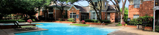 Luxury apartments with two resort-style swimming pools near the Mary Kay Museum with attached garages, golf course views, and beautiful landscaping in Dallas.