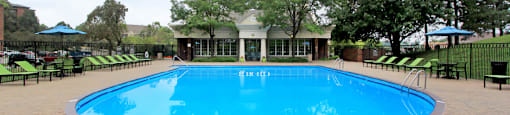 Resort-style saltwater pool with huge sun deck, poolside lounge chairs, and park-like setting with lots of trees and scenic views at Embassy Park Apartments in Omaha, Nebraska