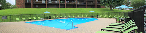 Resort-style saltwater pool with huge sun deck, poolside lounge chairs, and park-like setting with lots of trees and scenic views at Embassy Park Apartments in Omaha, Nebraska