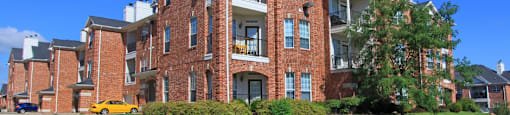 Luxury apartments with red brick exteriors, spacious balconies, lush landscaping, and scenic views at TurtleCreek apartments in West Des Moines, Iowa