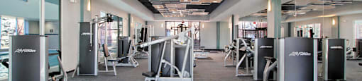 A gym with a variety of equipment including weights and machines.