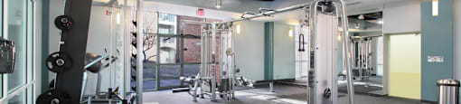 A gym with a variety of equipment including dumbbells and weight machines.
