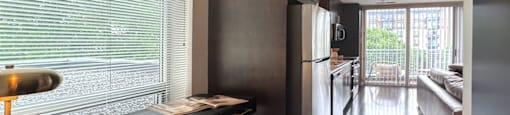 A modern kitchen with dark wood floors and a black refrigerator.