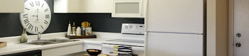Kitchen with white cabinets, lots of cabinet space, kitchen island, prep island, and colored feature wall at Embassy Park Apartments in Omaha, Nebraska