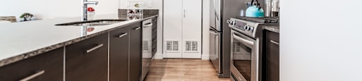 a kitchen with wooden floors and stainless steel appliances