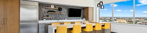 a kitchen with a long island with yellow chairs