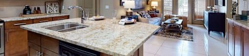 Luxury apartments in Bloomington Minnesota with spacious floor plan, granite countertops, stainless steel appliances, built-in wine rack, kitchen island, and porcelain tile floor at Luxembourg Apartments