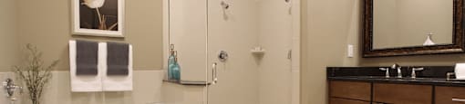 Luxury bathroom with granite countertops, glass shower and separate soaking tub at Luxembourg Apartments in Bloomington Minnesota