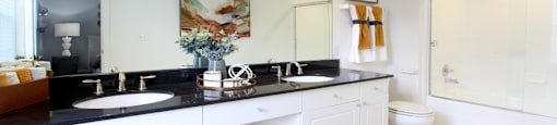 Spacious master bathroom with granite countertops, double sink vanity, double mirror vanity, at Tuscany Villas Apartments in Houston, Texas
