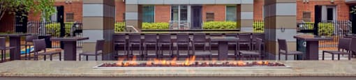 A modern building with a fire pit in front.