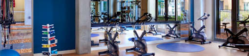 A gym with exercise equipment and a blue wall.