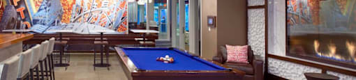 A pool table in a room with a mural on the wall.