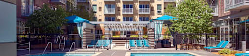 A large swimming pool in front of apartment buildings.