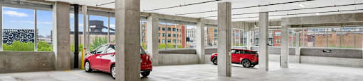 a parking garage with two red cars in it