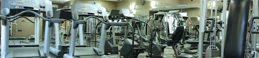 Luxury apartments with a fitness center in a gated community with red brick exteriors at Prestonbridge Apartments in North Dallas