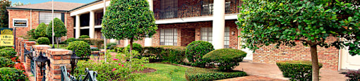 Apartments near the Galleria with brick exteriors, beautiful landscaping and courtyard setting at Plantation apartments in Houston.