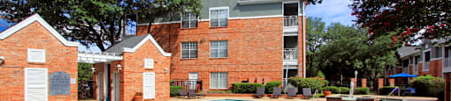 Luxury apartments with two resort-style swimming pools with fountain, poolside lounge chairs, and beautiful landscaping in Dallas.