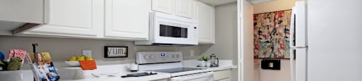 Bright white kitchen, spacious kitchen and full size and washer and dryer at Preston Village Apartments in North Dallas