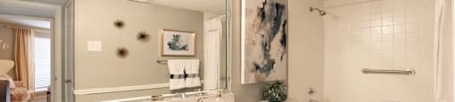 Spacious bathroom with white cabinets and white porcelain tile at Preston Village Apartments in North Dallas
