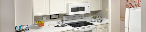 Bright white kitchen, spacious kitchen and full size and washer and dryer at Preston Village Apartments in North Dallas